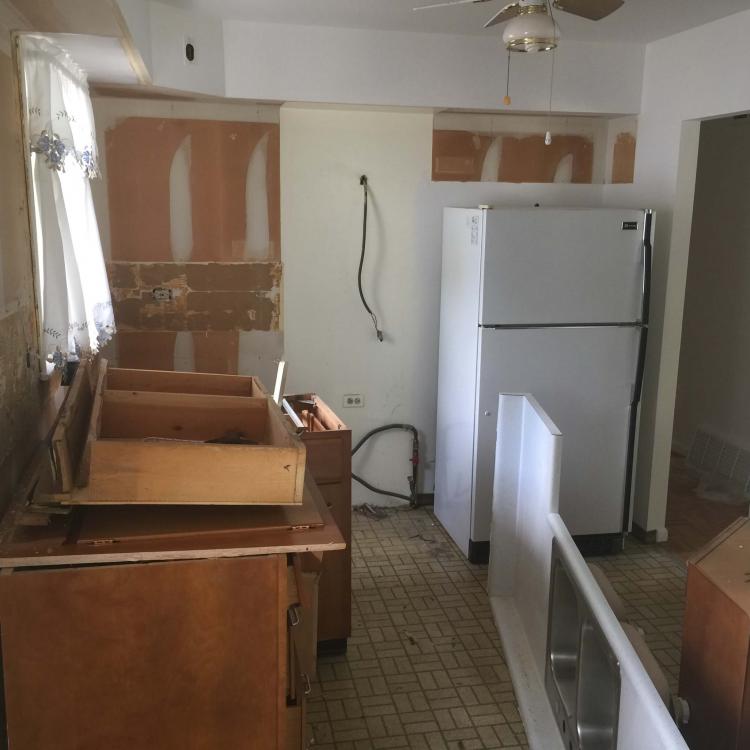 Kitchen remodel in progress: cabinets removed, walls open