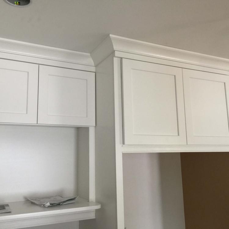 Kitchen remodel in progress: new white cabinets with crown molding