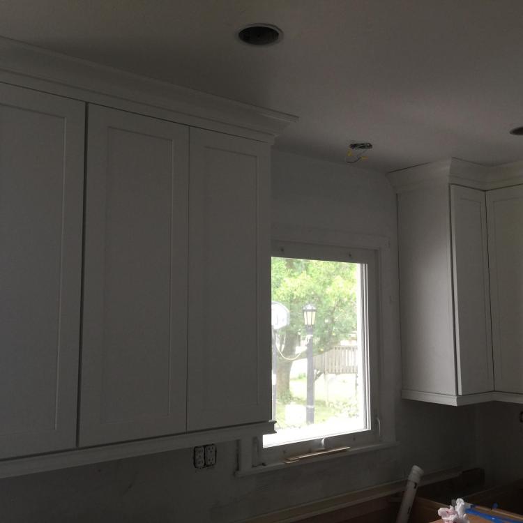 Kitchen remodel in progress: new white cabinets with crown molding