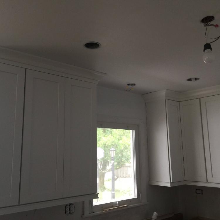 Kitchen remodel in progress: painted white cabinets with crown molding