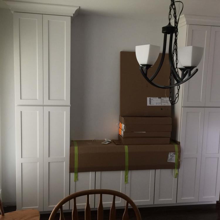 Kitchen remodel in progress: new white cabinets installed.