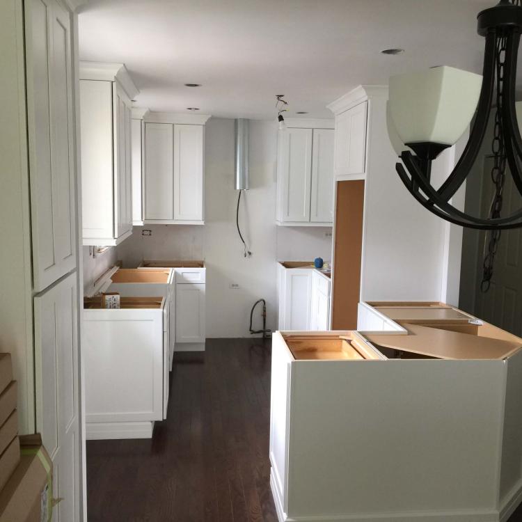 Kitchen remodeling: new white cabinets installed, countertops not yet installed.