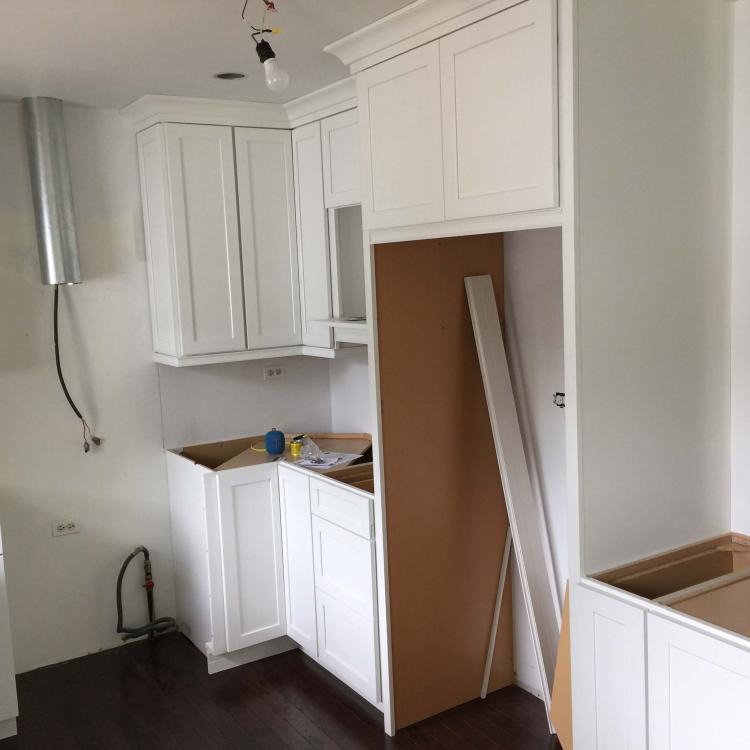 Kitchen remodeling: new white cabinets installed