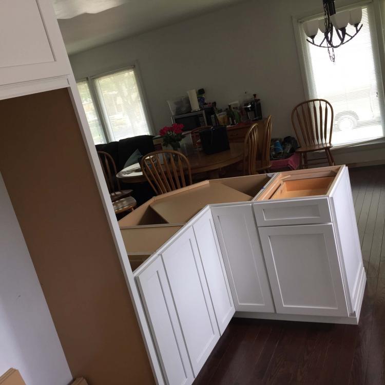 Kitchen remodel in progress: new white cabinets installed