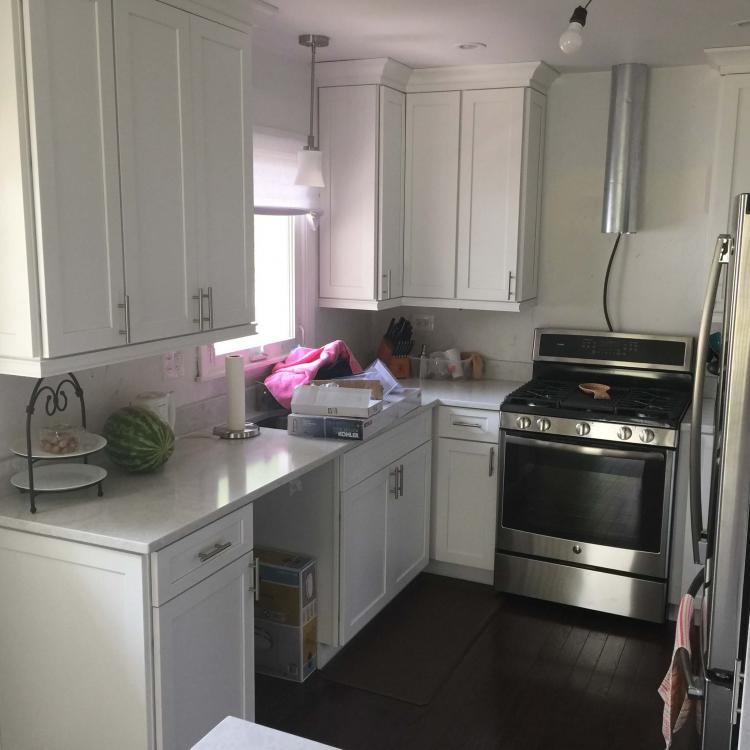 Kitchen remodel complete: white cabinets, quartz countertops, stainless steel appliances.