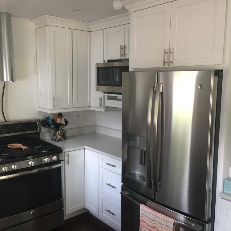 Kitchen remodel complete: white cabinets, quartz countertops, stainless steel appliances