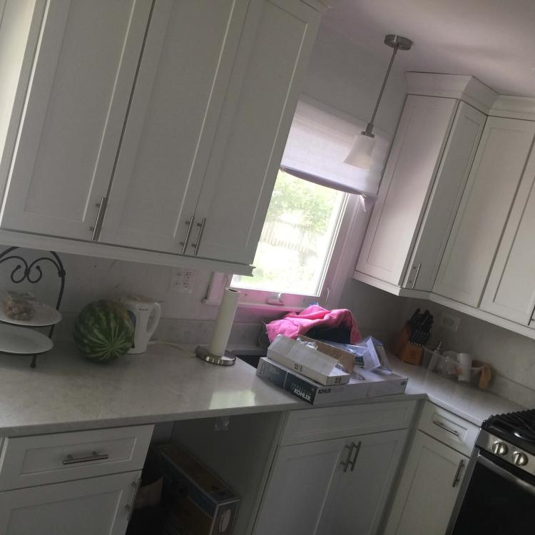 Kitchen remodeling complete: white cabinets, quartz countertops, and stainless steel appliances