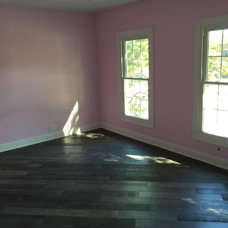 Completed bedroom renovation with a fresh coat of paint and new flooring.