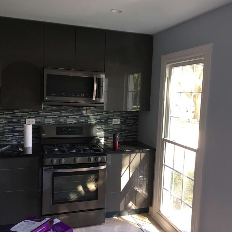 Completed kitchen renovation with modern appliances and a stylish backsplash.