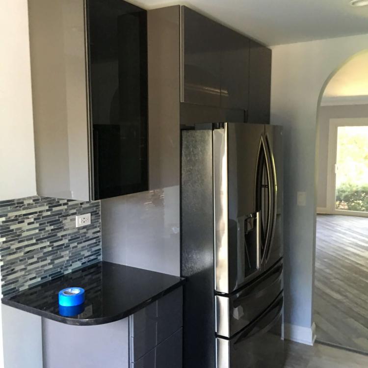 Renovated kitchen with dark cabinets and stainless steel appliances.