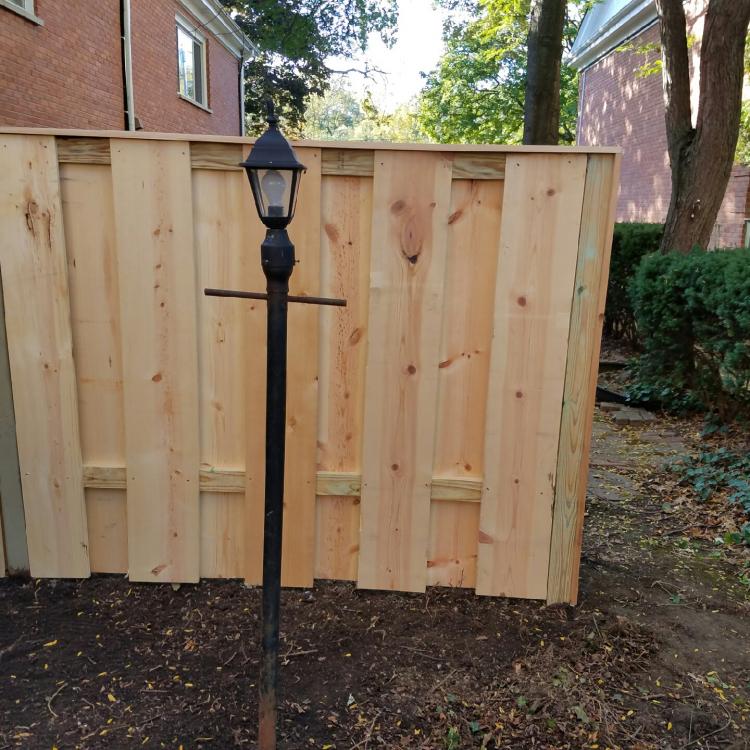 Completed renovation: backyard with a new fence and lamp post.