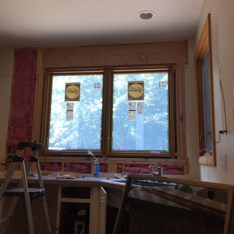 A kitchen with new windows and exposed framing.