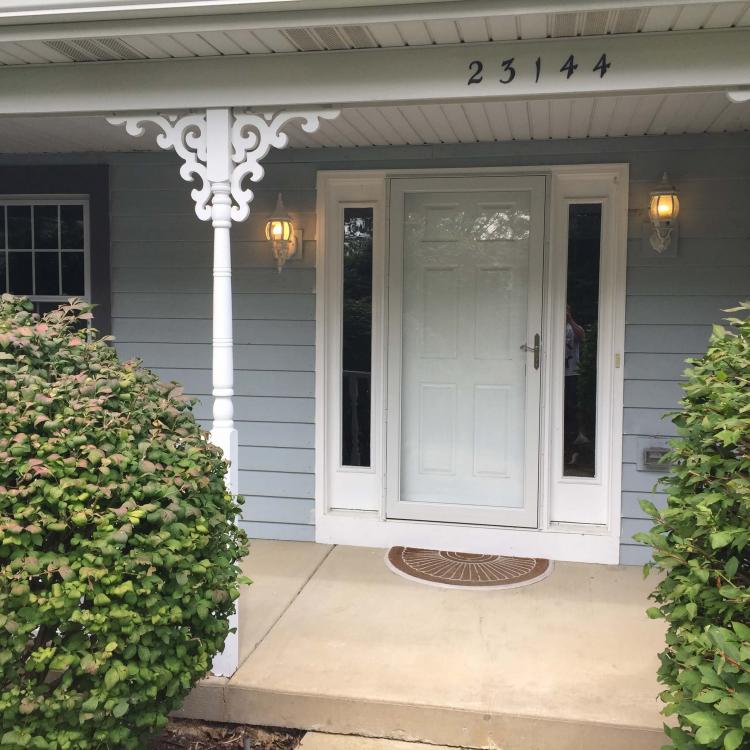 A house with a white front door and a newly installed storm door