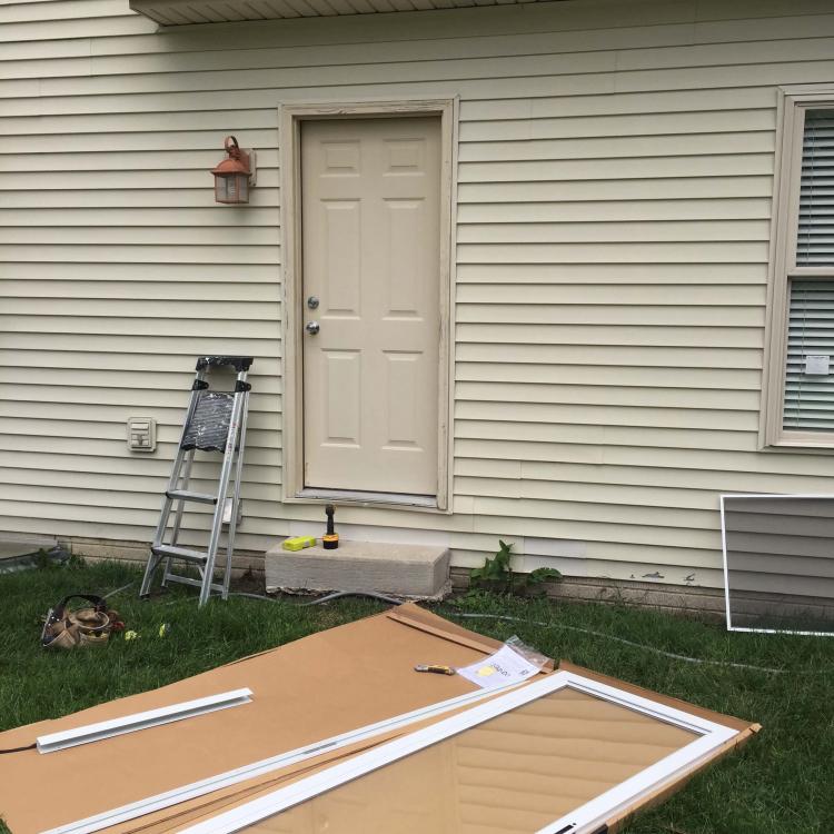 A new storm door ready to be installed on a house.