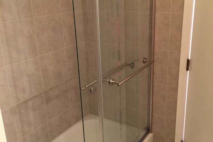 Bathroom renovation: Modernized shower with sliding glass door.