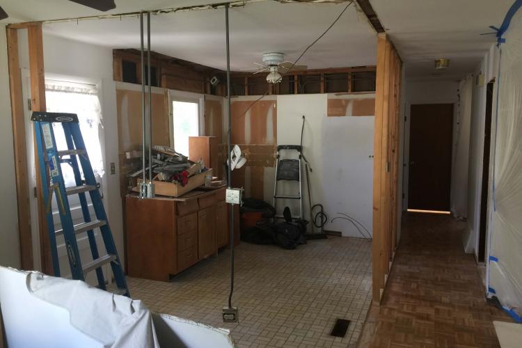 Mid-stage kitchen renovation with framing and wiring visible