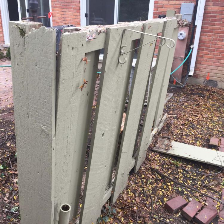 Broken wooden fence panel in need of replacement.