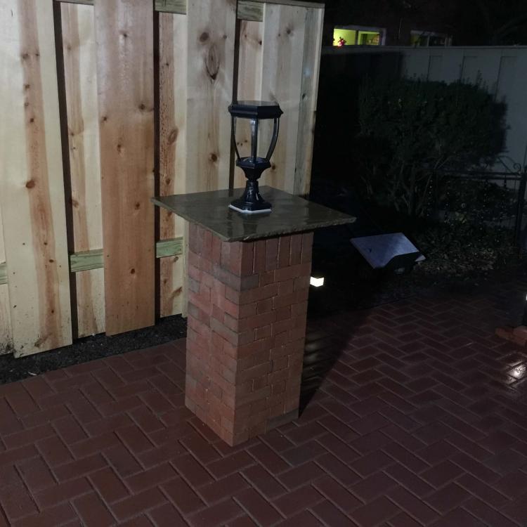 Backyard makeover: Brick lamp post and solar lights with repaired fence 