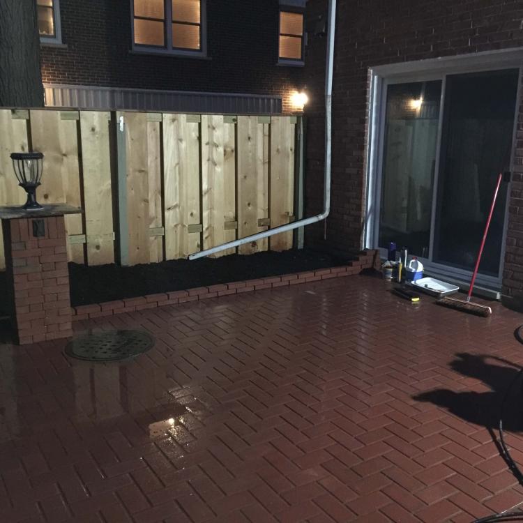 Outdoor living space improvement: Patio renovation with brick pavers and repaired fence