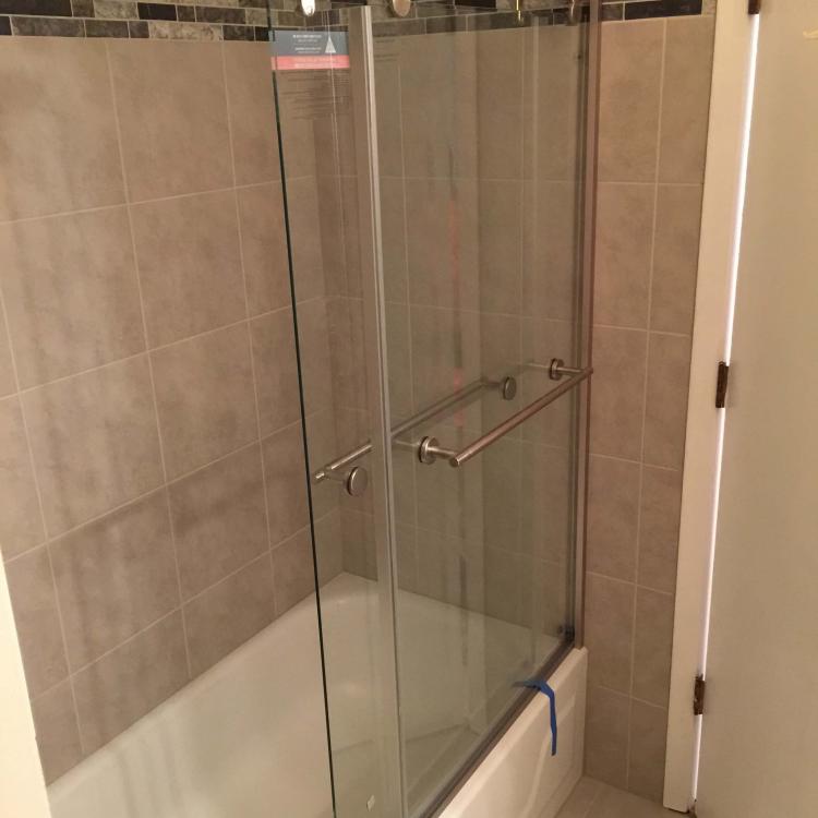 Bathroom renovation: Modernized shower with sliding glass door.