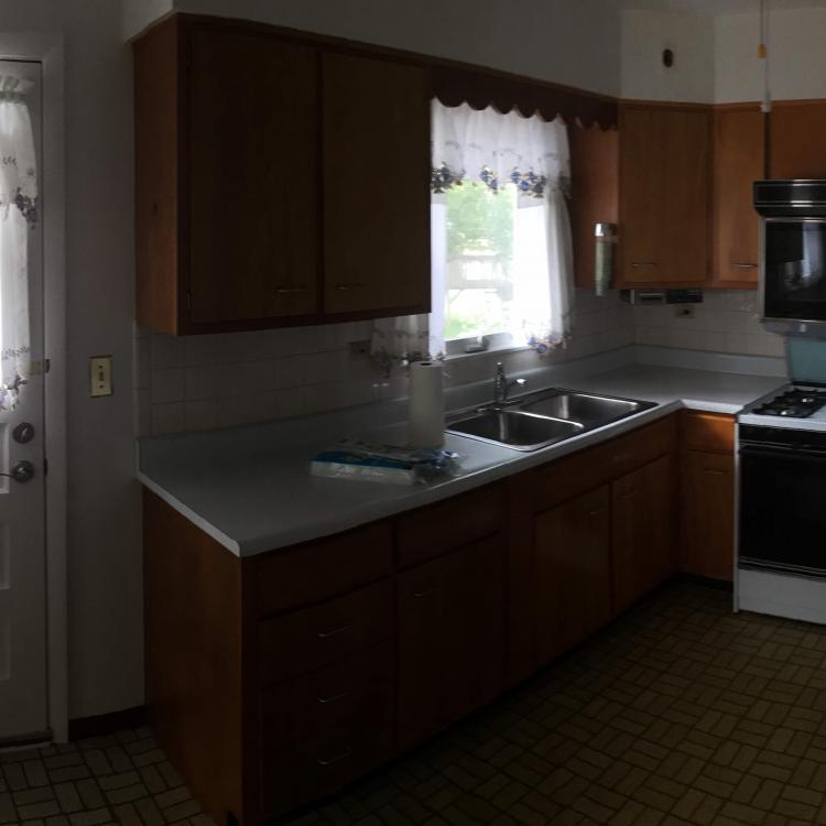 Dated kitchen with wood cabinets and appliances, ready for a renovation.