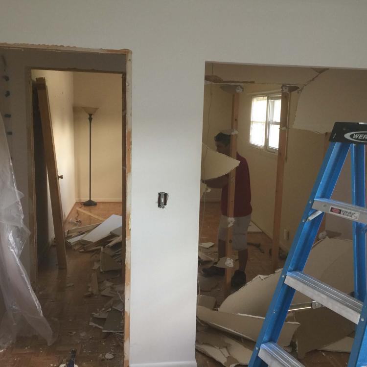 Mid-stage bedroom renovation with exposed framing and debris.