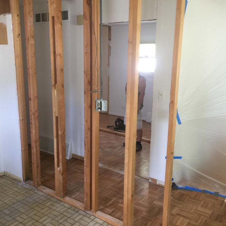 Room renovation with exposed framing and doorway