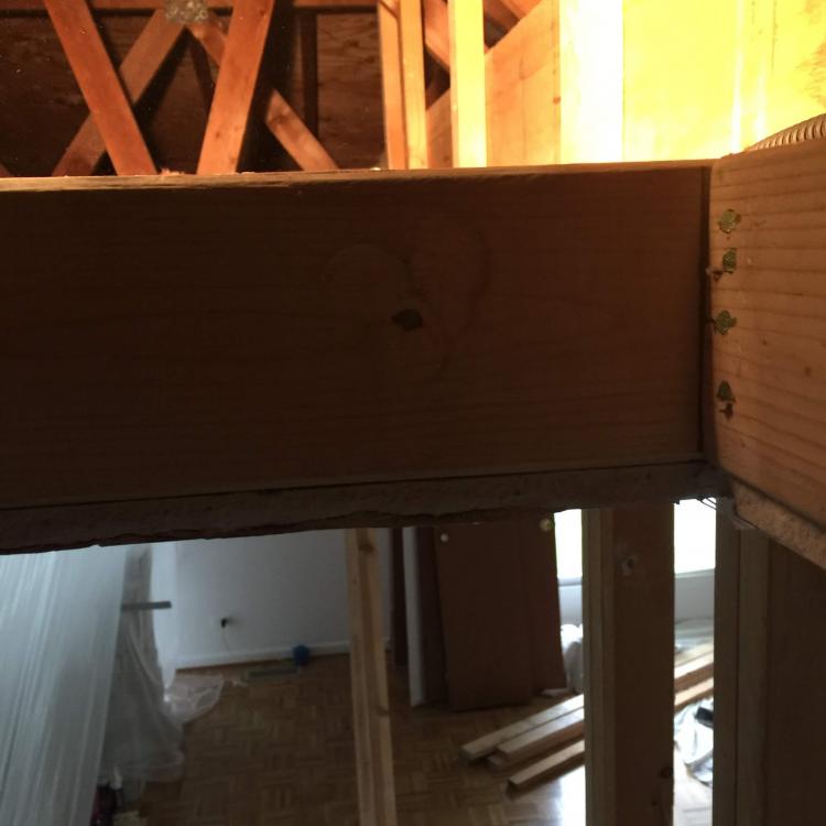 Attic renovation with exposed framing and a view of the room below