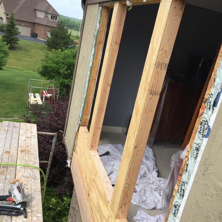 Damaged window frame being repaired with new framing.