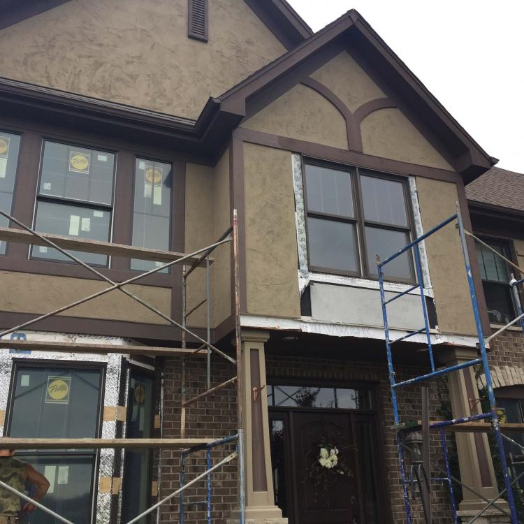 Exterior home improvement: House with scaffolding and window frame being replaced.