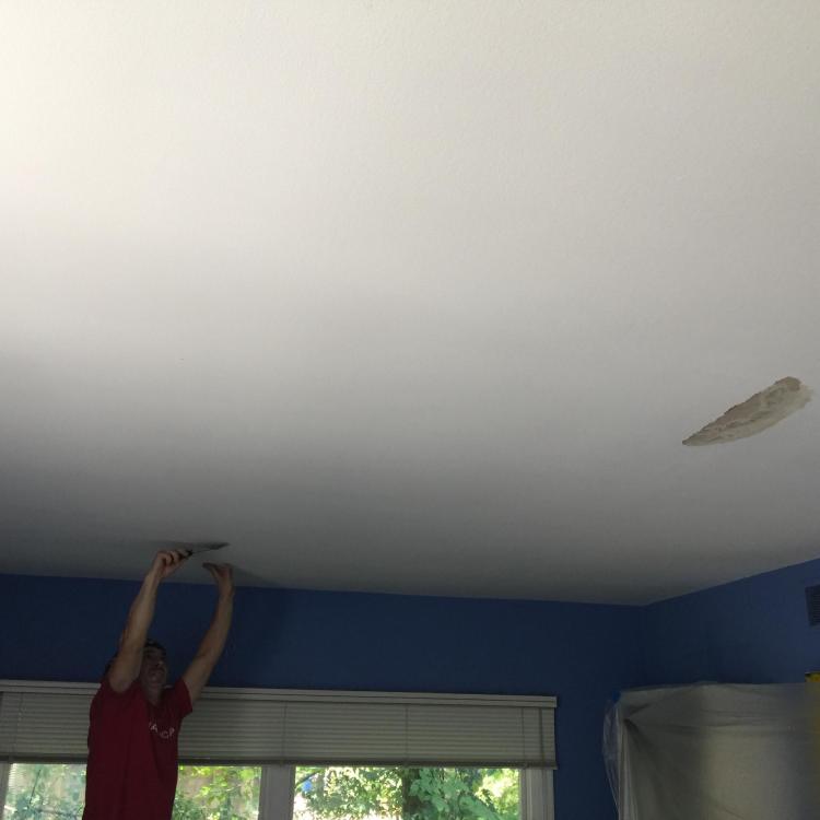 A worker while painting the ceiling