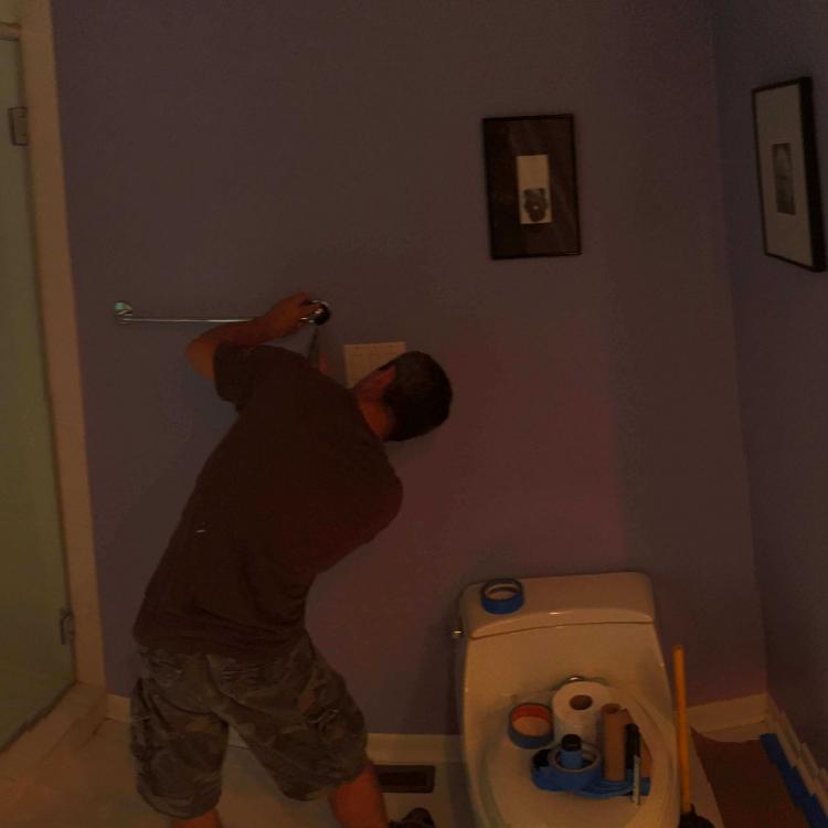 Interior painting in progress: painter applying color to wall.