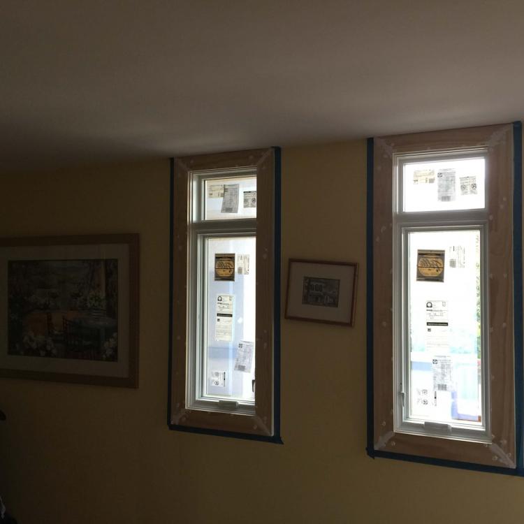 Interior view of a room with two new windows being installed