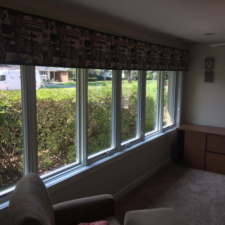 A row of newly installed, energy-efficient windows with curtains