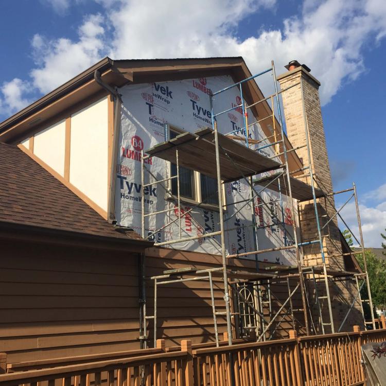 A house with scaffolding set up for wall repair work.