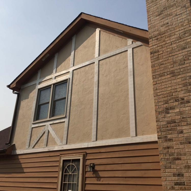 A house with stucco siding, and brick chimney indicating repaired walls