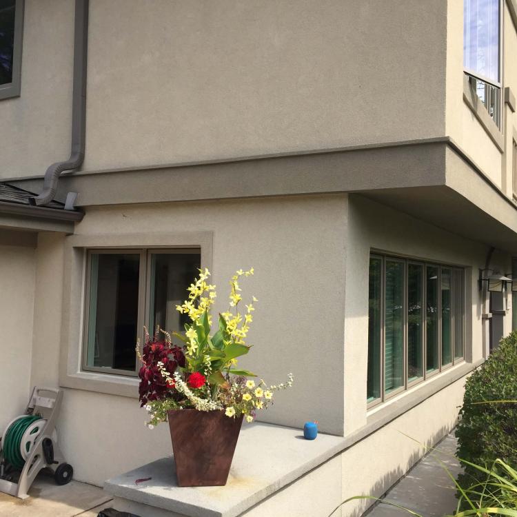 A close-up of several new windows installed on a house with a flower arrangement on a ledge