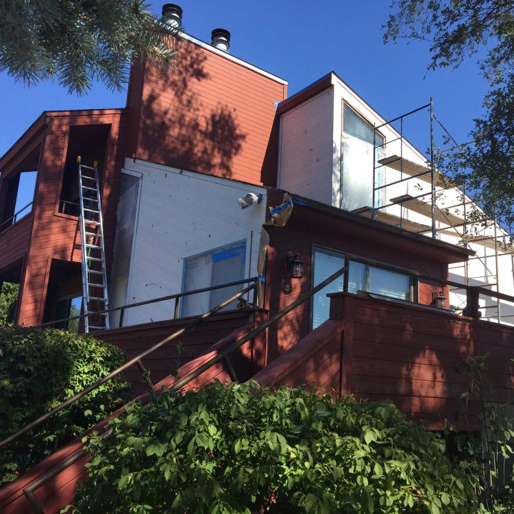 A house with scaffolding surrounding it, indicating ongoing siding replacement works