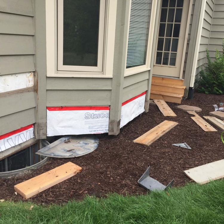 Damaged exterior of house, exposed wood, during siding repair