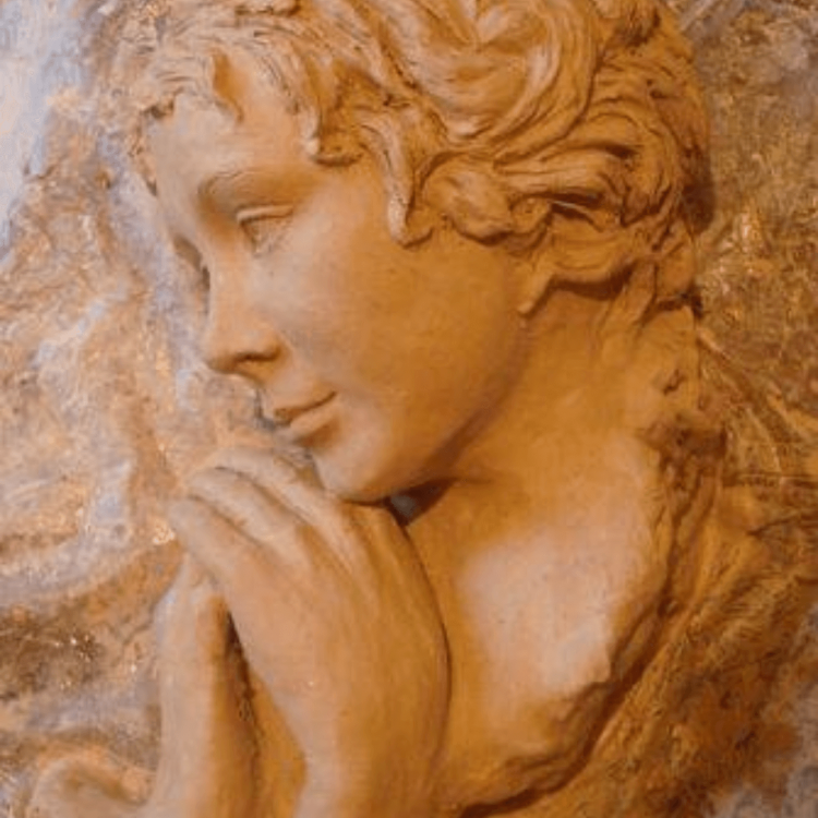 A close-up of a clay sculpture depicting the head and shoulders of a woman.